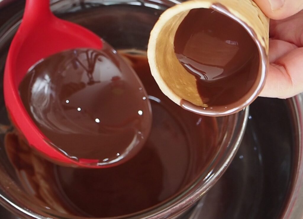 手順②　全体に薄くコーティングできるように、コーンを回しながら逆さにしてチョコレートを垂らす